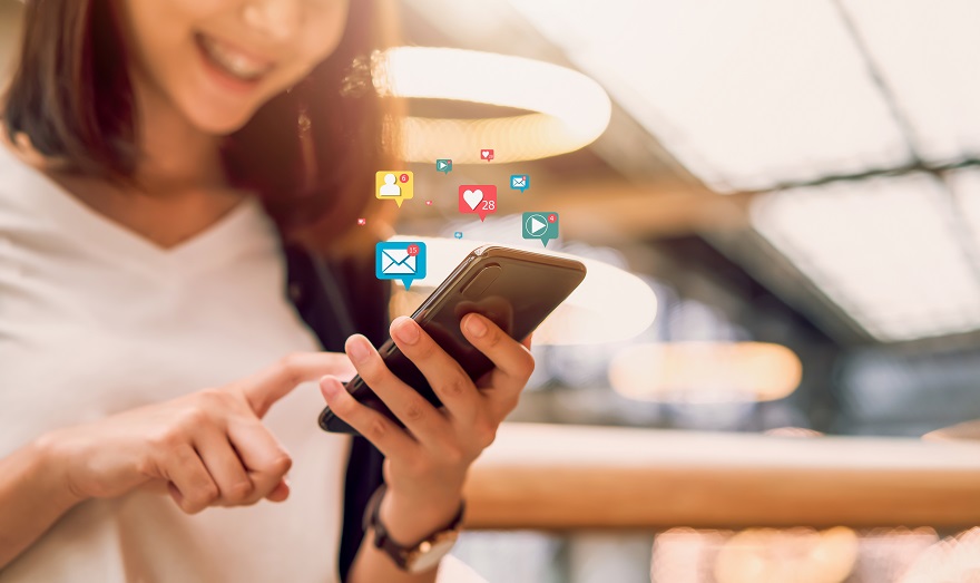 Social media and digital online concept, smiling Asian woman using smartphone and show technology icon.